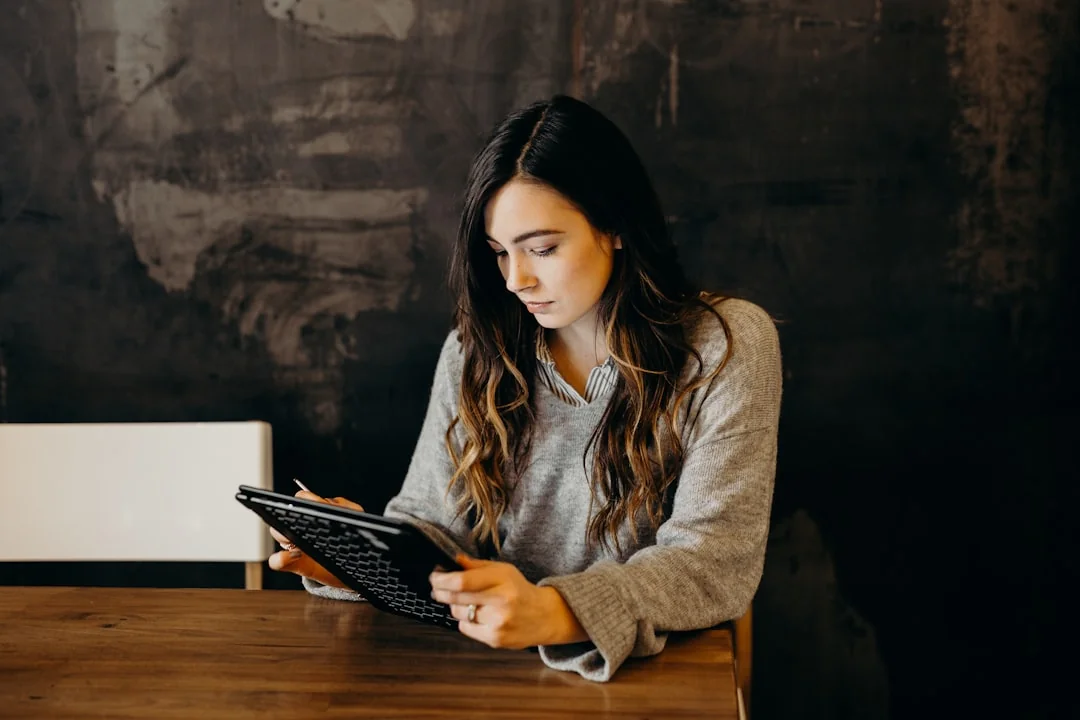 A professional man and woman discussing business strategies while using laptops in an indoor environment.